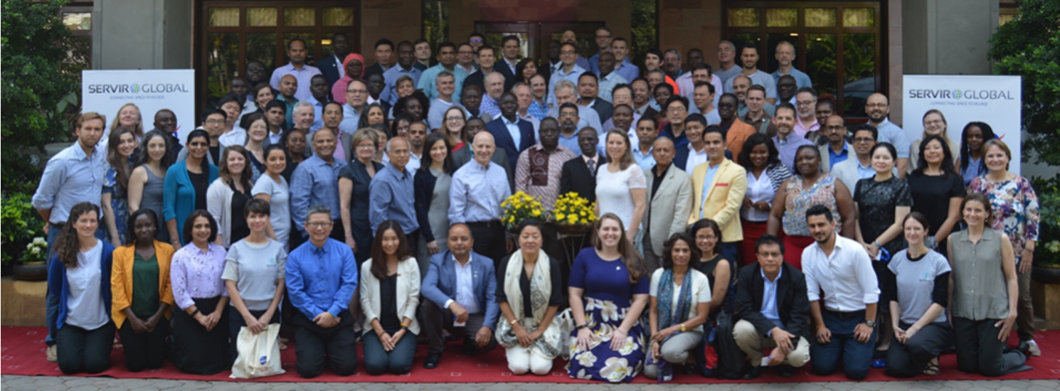 large group of people posing for picture in front of building