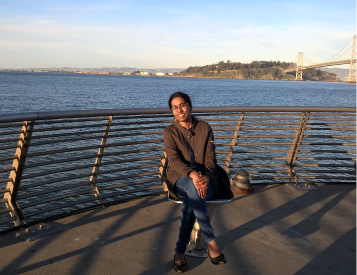 Girl on bench in front of water