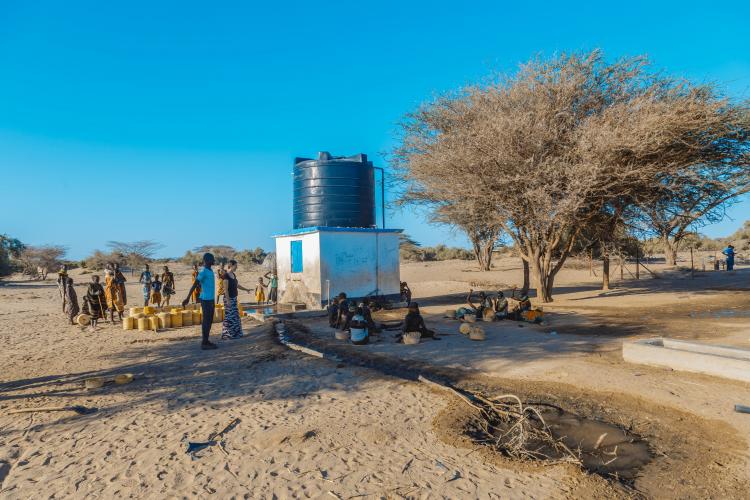 group of people near a groundwater pump