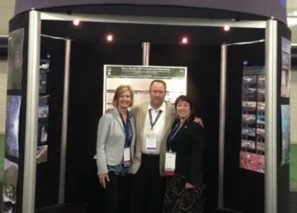 photo of a man and two women at a science conference