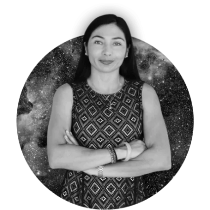 Woman in patterned dress stands with arms crossed in front of starry background in black and white