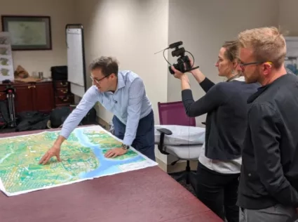 photo of NASA TV crew filming scientist in his office