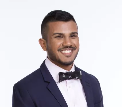 Man in bow-tie and blazer smiles for portrait 