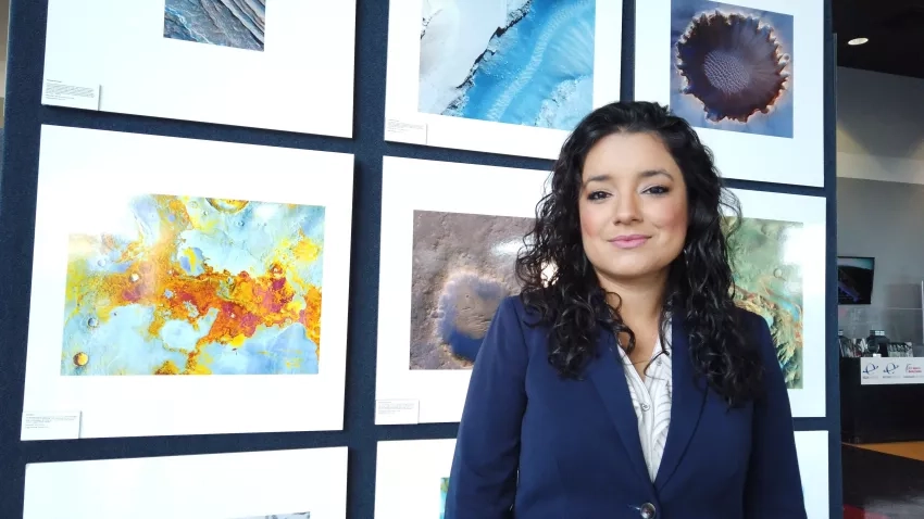 Photo of woman, Africa Flores, in front of display