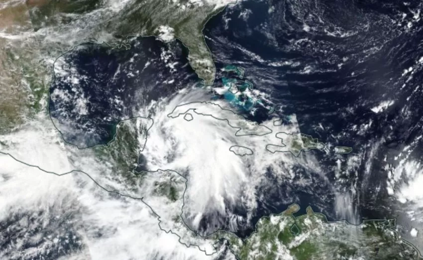 A satellite image of Hurricane Helene over the Gulf Coast, appearing as a large mass of swirling white and gray clouds.. 