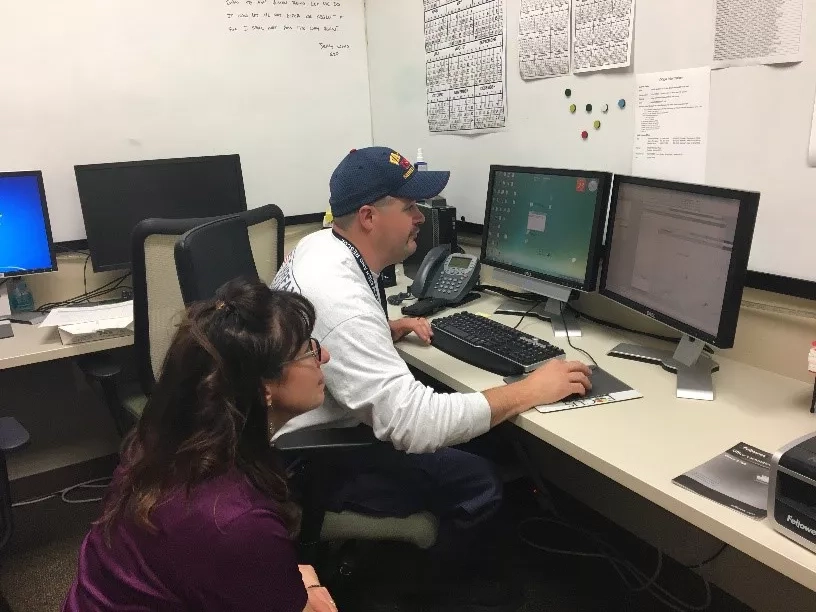 Schultz trains a member of the Search and Rescue team on integrating Geospatial Information Systems (GIS) data products into their workflow. Credits: Lori Schultz