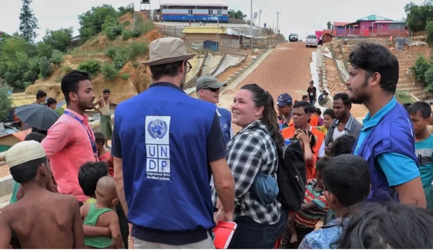 Shanna McClain speaks with a member of the United Nations Development Programme at a Rohingyan refugee camp. NASA provided the displaced community with data to reduce landslide risk in the refugee camps. NOTE: Some details in this photograph have been digitally obscured. Credits: NASA / Shanna McClain