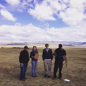 Photo of four people in field