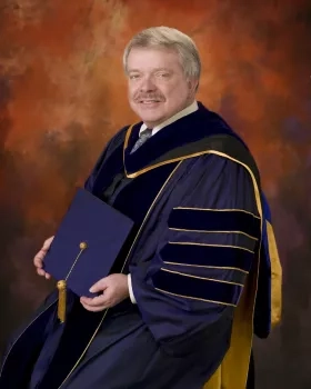 man sitting in collegiate gown