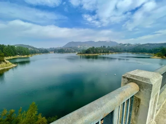 picture of teal lake under blue sky with light clouds