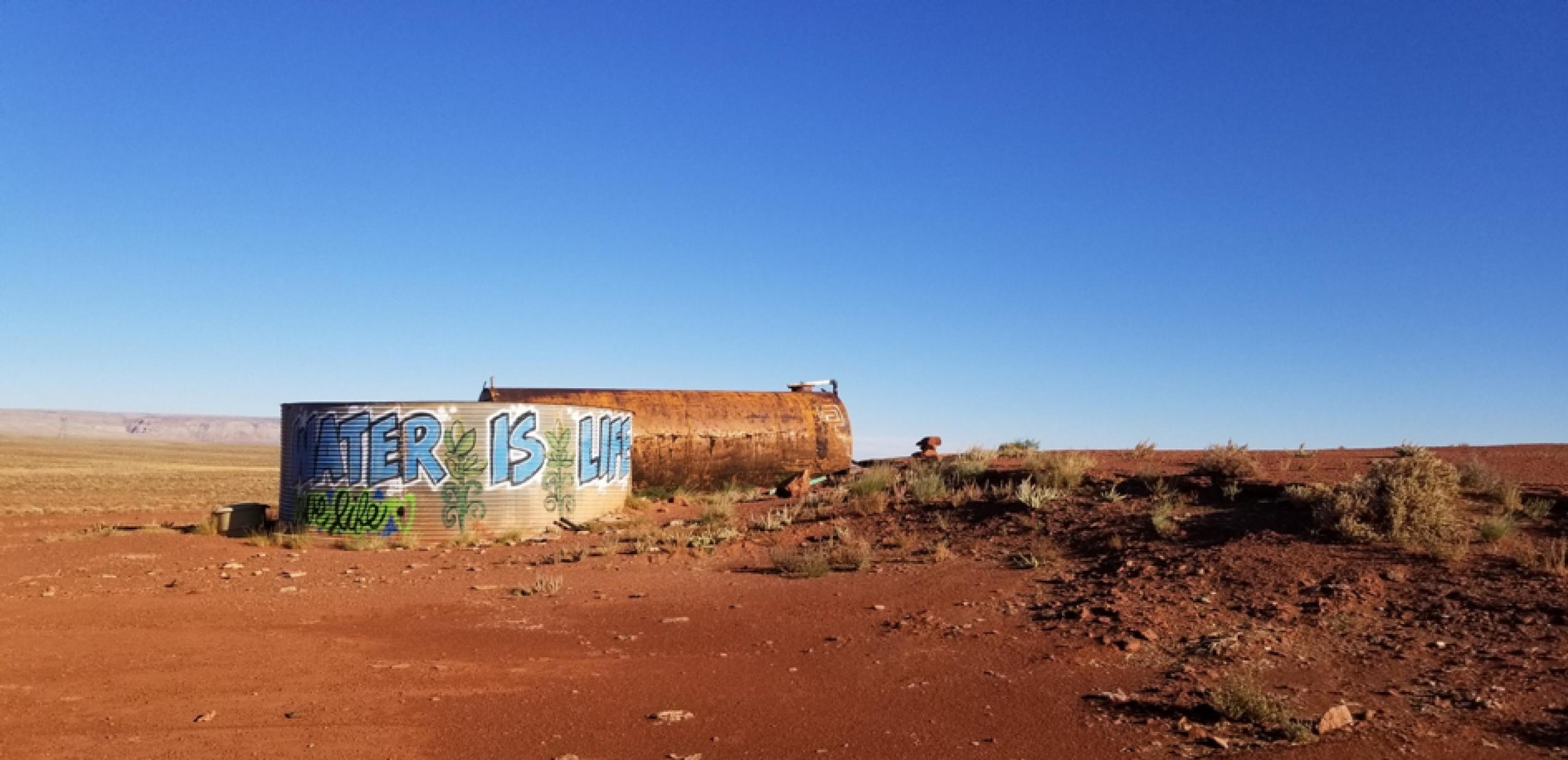 water tank in desert with "Water is Life" graffiti