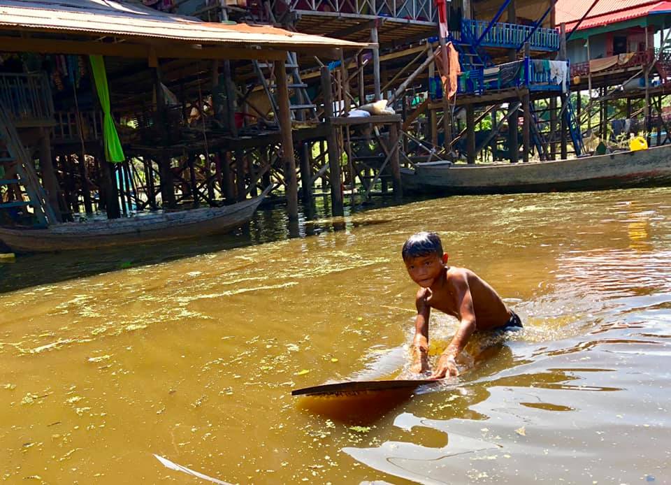 photo of boy swimming in river in Cambodia