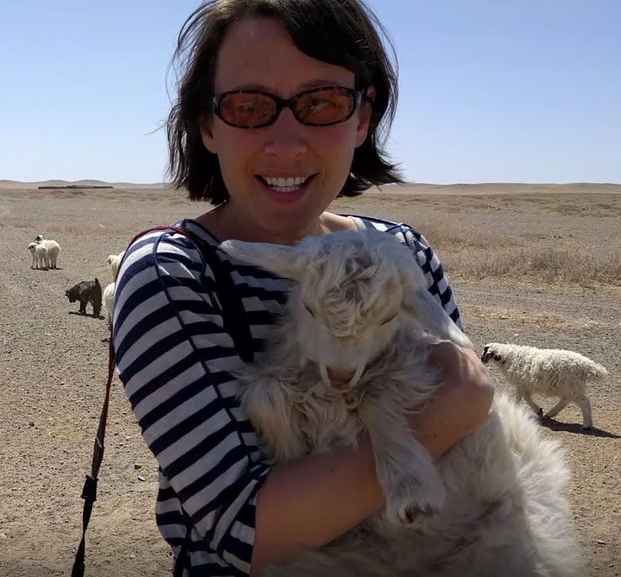 photo of woman holding goat in Mongolia