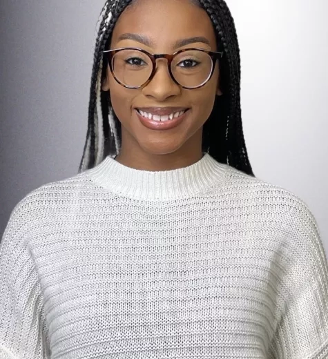 Kendall smiles at the camera in front of a white background.