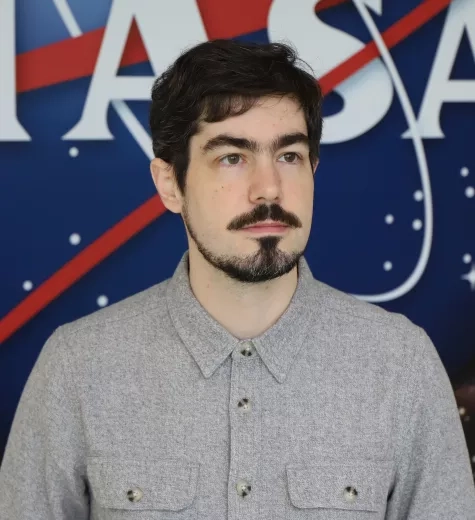 Carl pictured in front of the original NASA logo