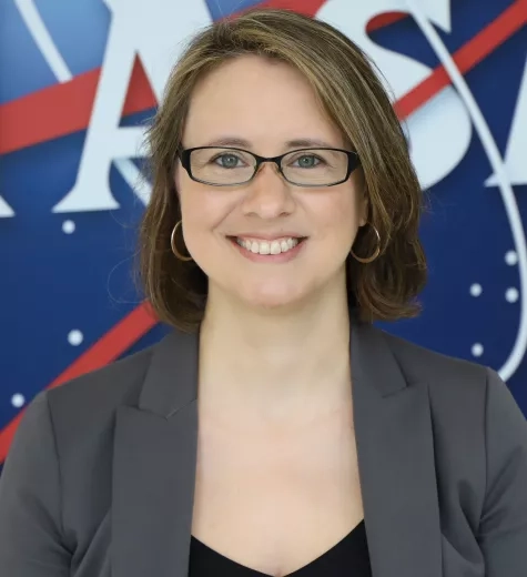 Photo of Melanie standing in front of the original NASA Logo