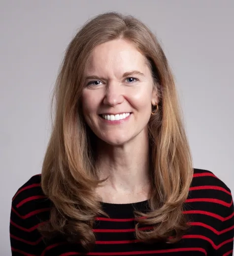 photo of Eleanor stokes on neutral gray background wearing a black and red horizontal stripe top