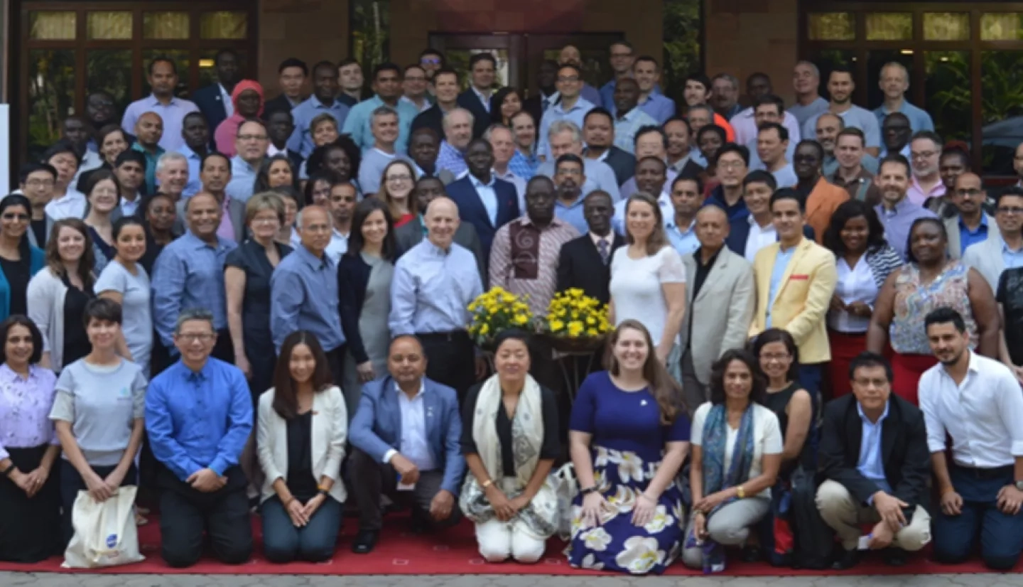 large group of people posing for picture in front of building