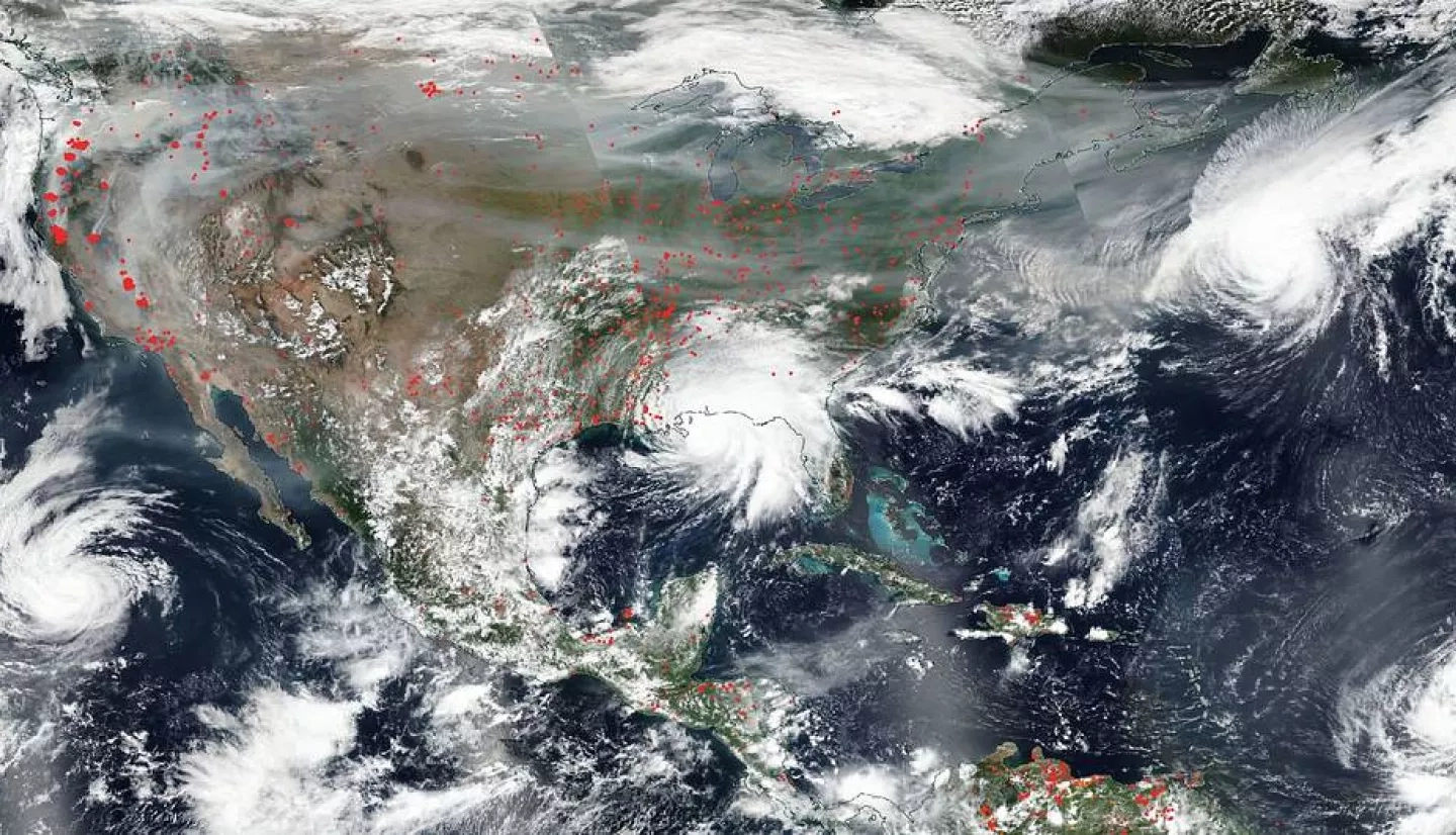 This image captured by the NOAA/NASA Suomi NPP satellite on Sep. 15, 2020 shows intense wildfires in the west (red dots) and smoke drifting across the country while several hurricanes formed – including Hurricane Sally as it stalled over Alabama (center). Credits: NASA Worldview, Earth Observing System Data and Information System