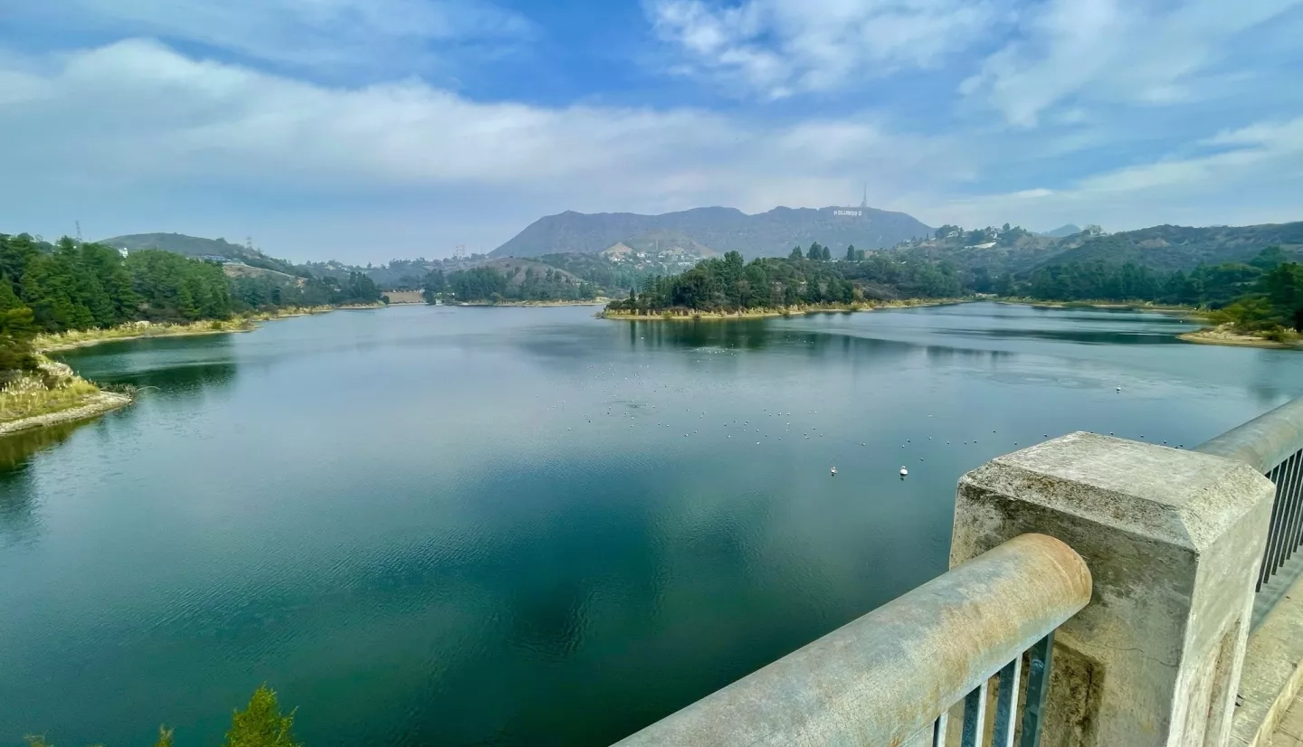 picture of teal lake under blue sky with light clouds