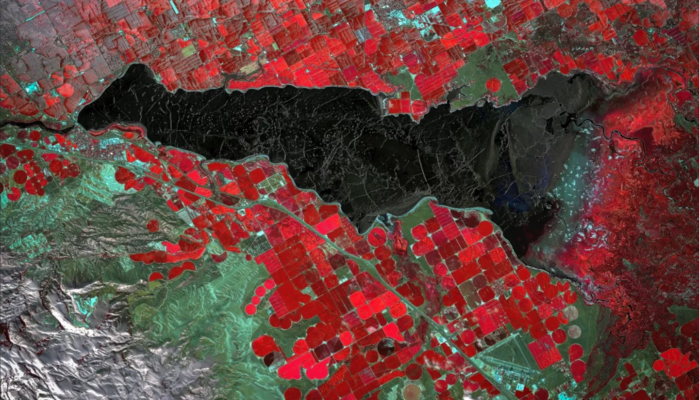 This image shows the mixed environments near the American Falls Reservoir throughout the year, blended using 2022 summer and winter NDVI false-color composites derived from Landsat 8 OLI and overlaid by a hillshade from SRTM. The white color indicates snowpack in the mountain wilderness, the primary water resource for agriculture and habitats near the reservoir. Bright red denotes marshes and irrigated farms, essential resources for wildlife animals and humans living in Southern Idaho.