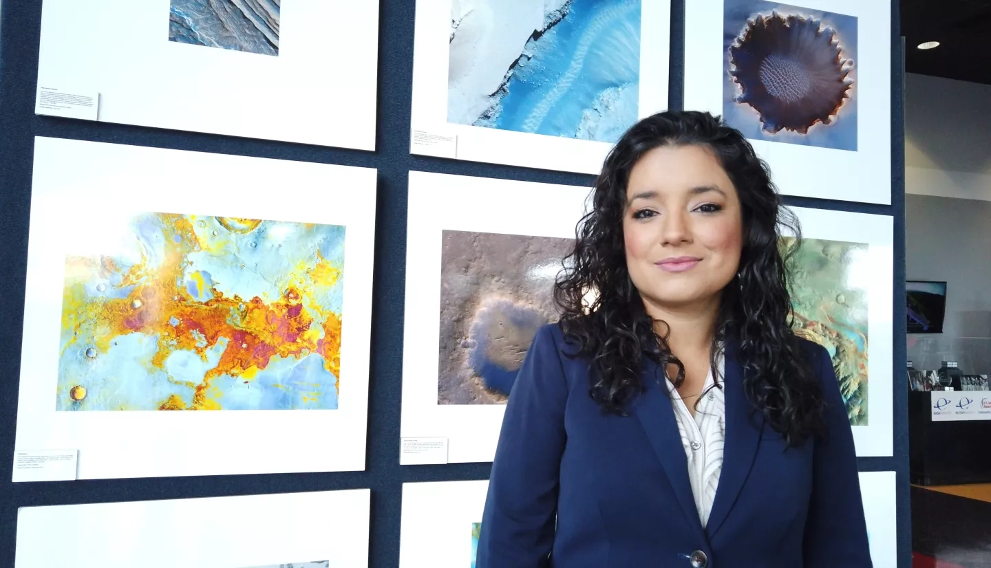 Photo of woman, Africa Flores, in front of display