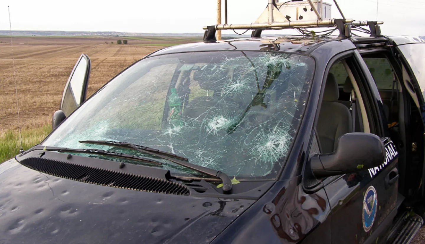 Car with damage to hood and windshield by hail