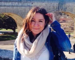 Photo of woman in front of bridge