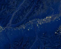 Normalized Difference Water Index (NDWI) to visualize drainage networks around the Unalakleet River in Alaska, calculated from an August 2021 Landsat 8 OLI image. Yellow represents standing or flowing water and potential flood zones, while the dark blue represents drier, upland regions. Unalakleet's climate resilience planning prioritizes relocation to upland regions while avoiding areas that have experienced significant permafrost degradation.