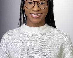 Kendall smiles at the camera in front of a white background.