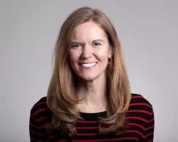 photo of Eleanor stokes on neutral gray background wearing a black and red horizontal stripe top