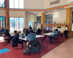 A group of people sit around a table indoors.