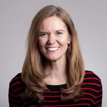 photo of Eleanor stokes on neutral gray background wearing a black and red horizontal stripe top