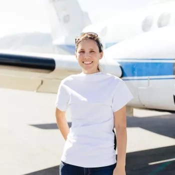 Photo of Melissa in white T-shirt in front of a small NASA branded plane