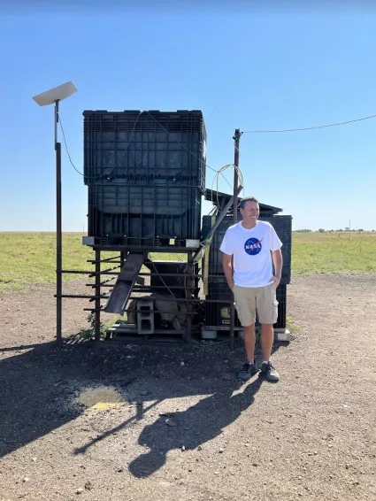 man standing in front of corn feeder