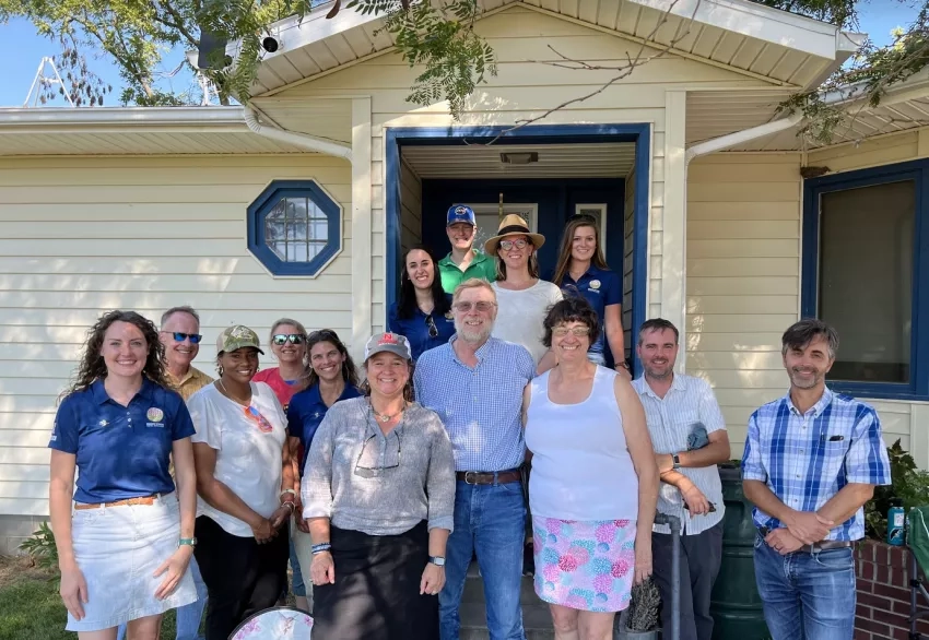 group photo of people standing in front of a house